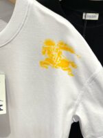 T-shirt bianca con grafica gialla di leone, stile sportivo e moderno, contrasto con maglietta nera.
