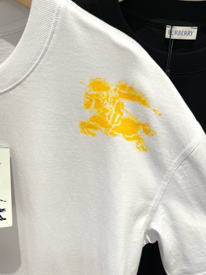 T-shirt bianca con grafica gialla di leone, stile sportivo e moderno, contrasto con maglietta nera.