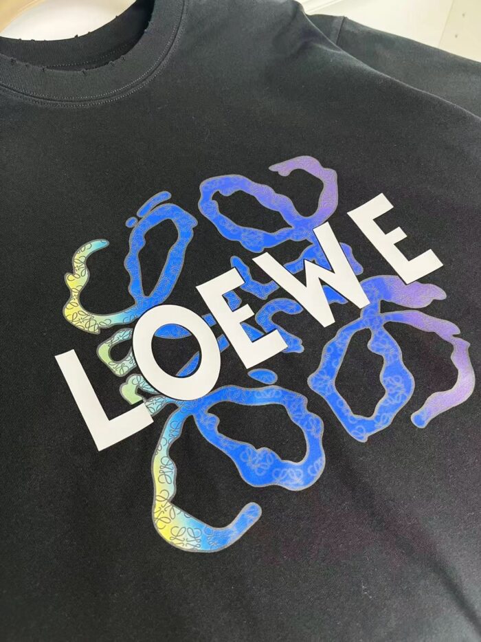 T-shirt Loewe nero con logo bianco e forme astratte colorate moderne.