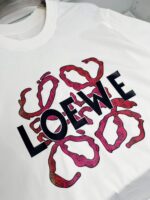 T-shirt bianca LOEWE con design artistico, colori vivaci e grafica moderna.