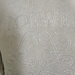Maglietta elegante con logo LOEWE ricamato e dettagli decorativi in stile minimalista.