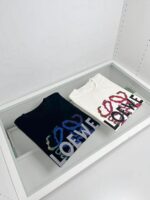 Magliette Loewe con design interlock in esposizione in altezza in stile minimalista.