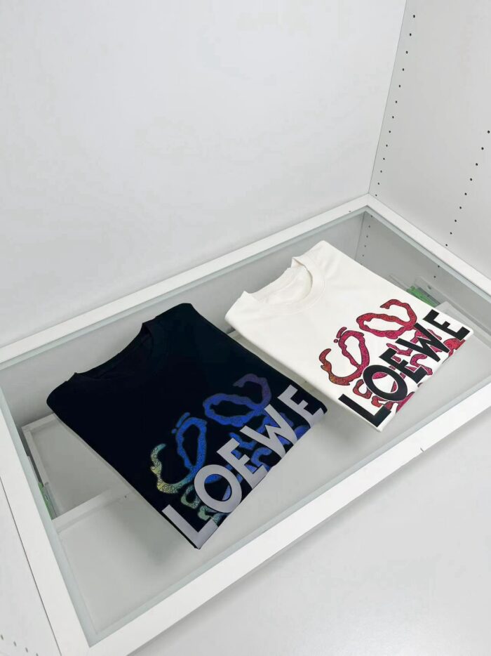Magliette Loewe con design interlock in esposizione in altezza in stile minimalista.