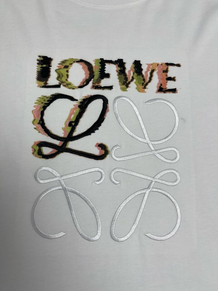 Maglietta LOEWE con logo colorato, dettagli ricamati e design moderno su sfondo bianco.