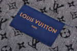 Etichetta Louis Vuitton su tessuto denim con motivi iconici, simbolo di lusso e stile italiano.