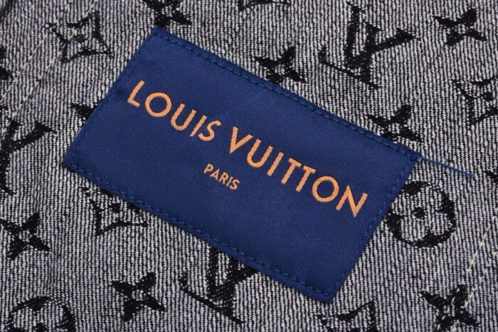 Etichetta Louis Vuitton su tessuto denim con motivi iconici, simbolo di lusso e stile italiano.