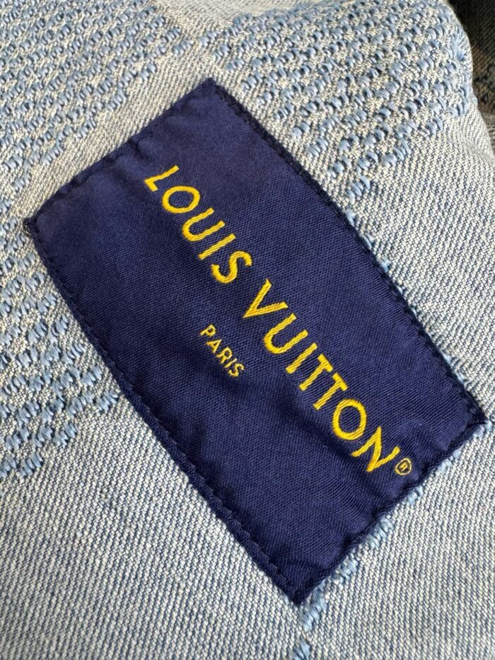 Etichetta Louis Vuitton su tessuto di lusso con logo in oro e dettagli eleganti.