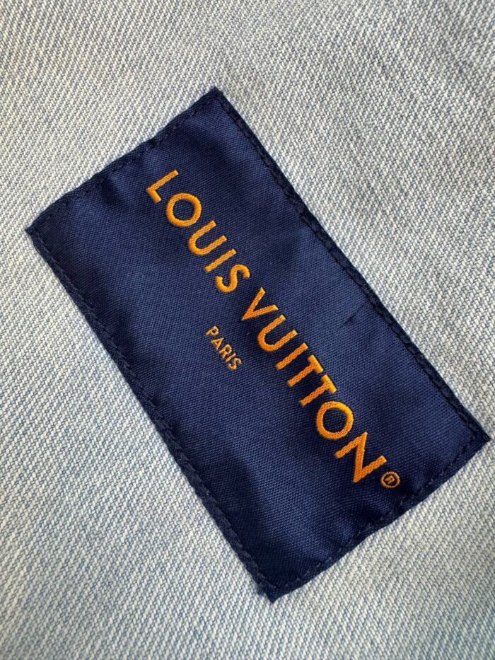 Etichetta Louis Vuitton in blu navy con scritte arancioni, simbolo di lusso e alta moda.