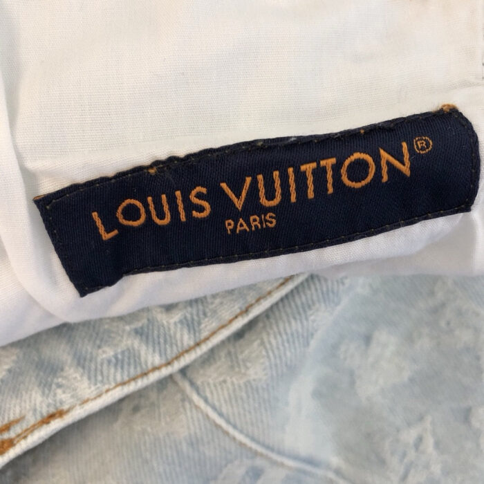 Etichetta Louis Vuitton su abito bianco di lusso, simbolo di eleganza e prestigio.
