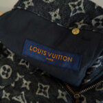 Dettaglio del logo Louis Vuitton su tessuto monogramma, alta moda e artigianato di lusso.