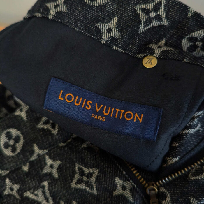 Dettaglio del logo Louis Vuitton su tessuto monogramma, alta moda e artigianato di lusso.