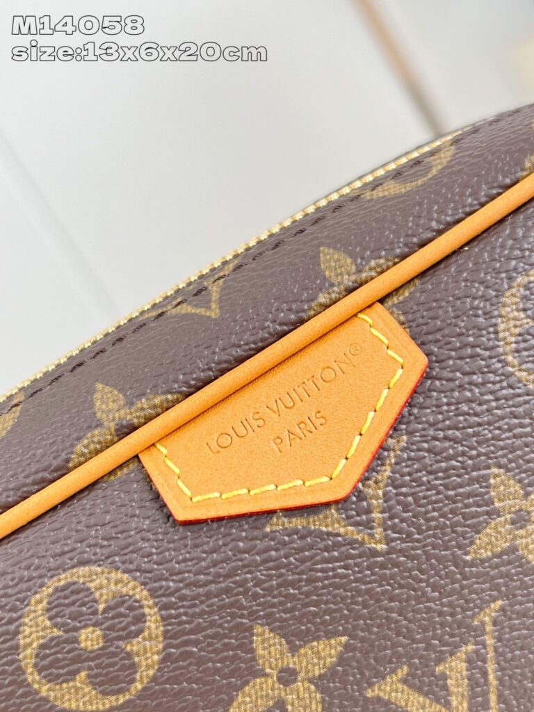 Dettaglio near di borsa Louis Vuitton Monogram con targa arancione in pelle.