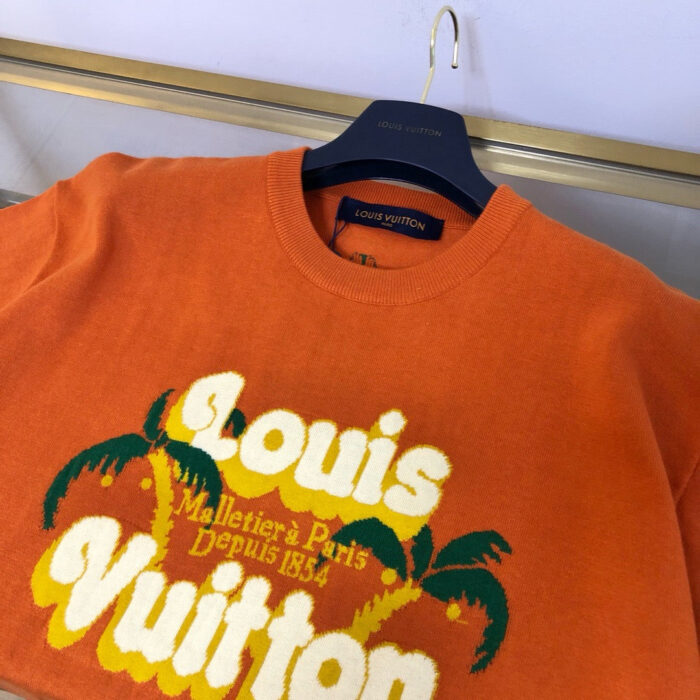Maglietta arancione Louis Vuitton con logo iconico, palme e stile estivo casual elegante.
