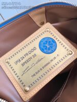 Dettagli interno della borsa Louis Vuitton Speedy 30, tag di lusso in oro con logo e stile raffinato.