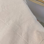Tessuto beige elegante con motivo geometrico raffinato e dettagli lucidi, perfetto per arredamento di lusso.