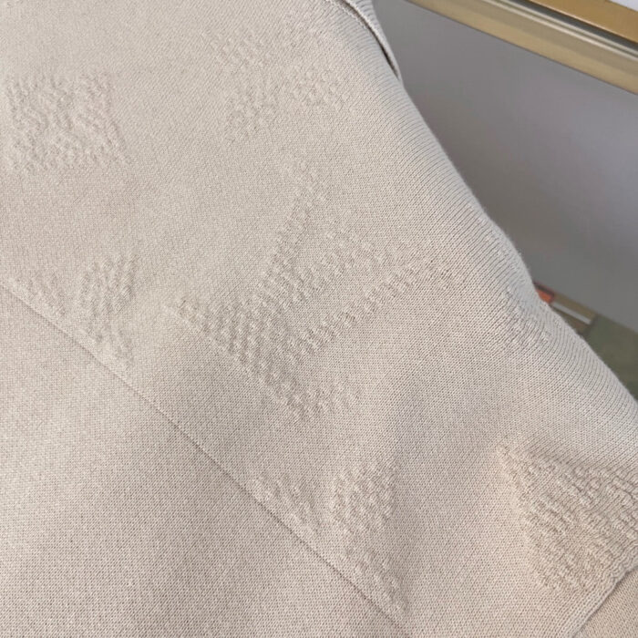 Tessuto beige elegante con motivo geometrico raffinato e dettagli lucidi, perfetto per arredamento di lusso.