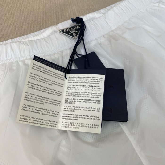 Pantaloncini sportivi bianchi Prada di lusso con etichette e stile minimalista elegante.