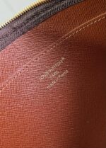 Interno di borsa di lusso con logo embossato Christopher e dettagli in pelle marrone raffinata.