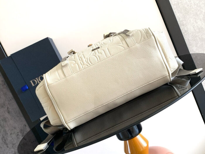 Borsa beige Dior elegante con dettagli metallici su tavolo raffinato, in stile luxury.