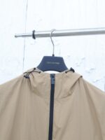 Giacca beige Louis Vuitton con cappuccio, zip elegante, perfetta per look casual e sofisticati.