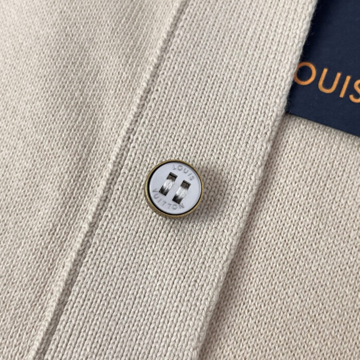 Cardigan beige di lusso con bottone metallico, tessuto morbido e dettagli raffinati.