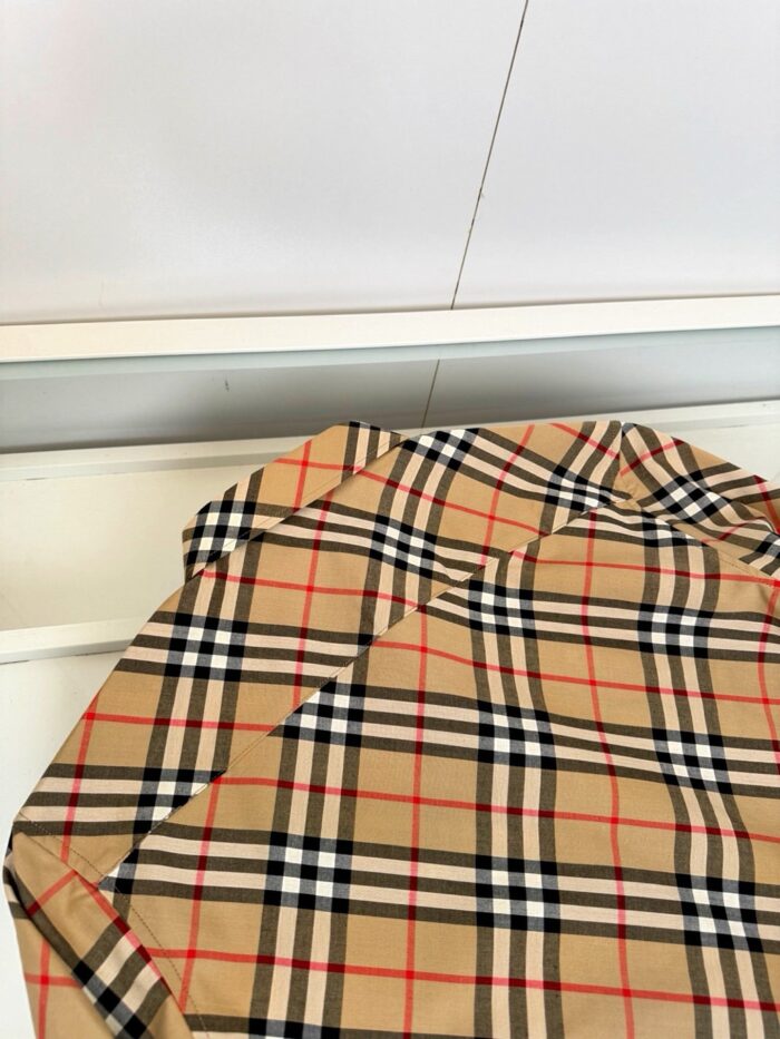 Tessuto tartan beige di lusso con dettagli eleganti in nero, rosso e bianco.