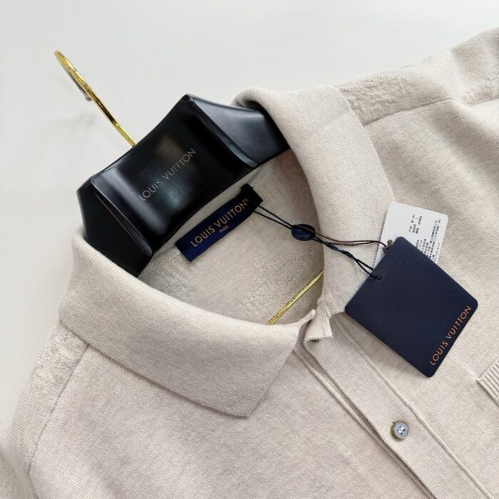 Camicia beige Louis Vuitton in lino elegante, dettagli raffinati, appesa su appendino nero con logo.