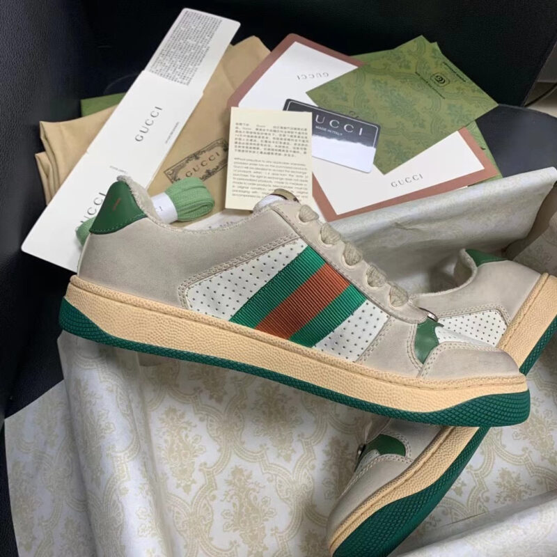 Sneakers di lusso beige con dettagli verde e arancione in confezione elegante e premium.