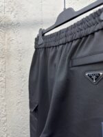 Pantaloni athleisure neri di lusso con vita elasticizzata, tasca e logo discreto.