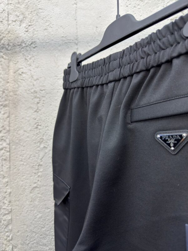 Pantaloni athleisure neri di lusso con vita elasticizzata, tasca e logo discreto.