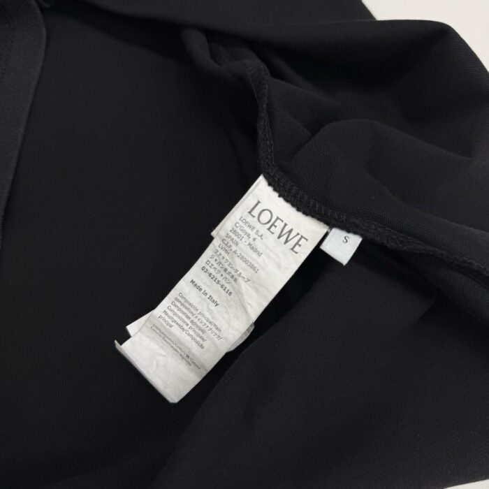 Giacchetto nero di lusso LOEWE con etichetta cura, tessuto morbido e dettagli eleganti.