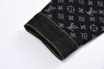 Cuff in denim nero con dettagli logo e cucitura gialla, stile moderno e di lusso.
