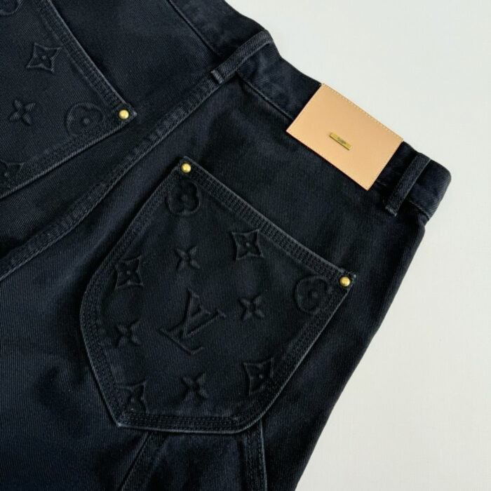 Jeans neri di lusso con logo embossato, dettagli eleganti e rivetti dorati.