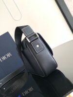 Borsa Dior nera di lusso con dettaglio flap e logo, su superficie riflettente elegante.