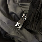Zip di lusso con logo LV su tessuto nero satinato, dettaglio elegante e raffinato.