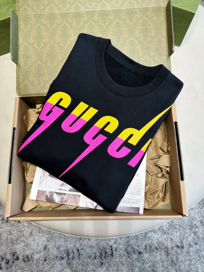 Maglietta Gucci nera in confezione elegante con design colorato e attenzione ai dettagli.