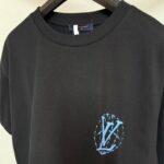 Maglietta nera con logo blu interlacciato, stile streetwear minimalista e di alta qualità.