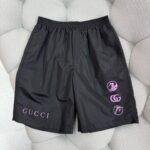 Shorts Gucci neri moderni con logo bianco e dettagli grafici circolari streetwear.