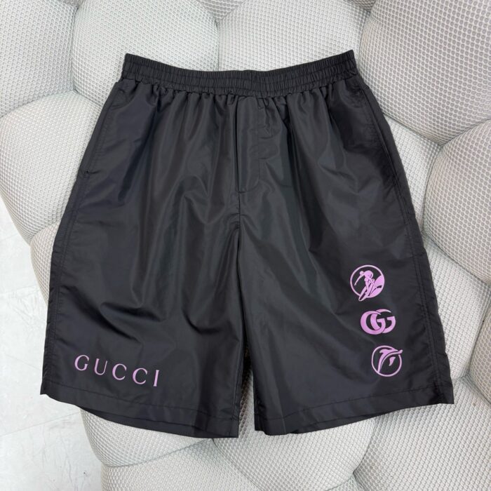 Shorts Gucci neri moderni con logo bianco e dettagli grafici circolari streetwear.