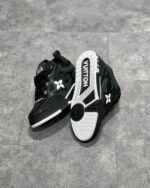 Sneaker di lusso nere high-top con logo bianco, dettagli in pelle e suola robusta.