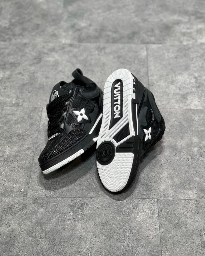 Sneaker di lusso nere high-top con logo bianco, dettagli in pelle e suola robusta.