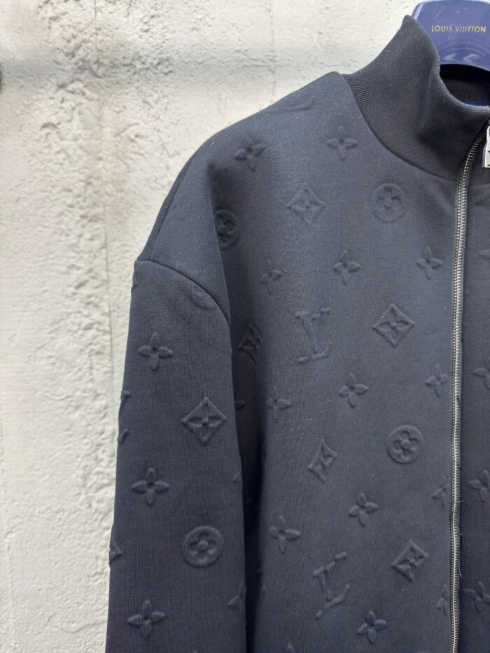 Giacca nera di lusso con motivi embossati, zip frontale e stile moderno ed elegante.