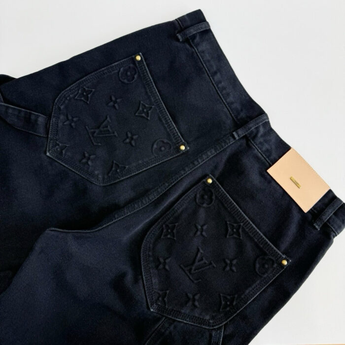 Jeans neri di lusso con tasche monogramma, dettagli in oro e patch in pelle raffinata.