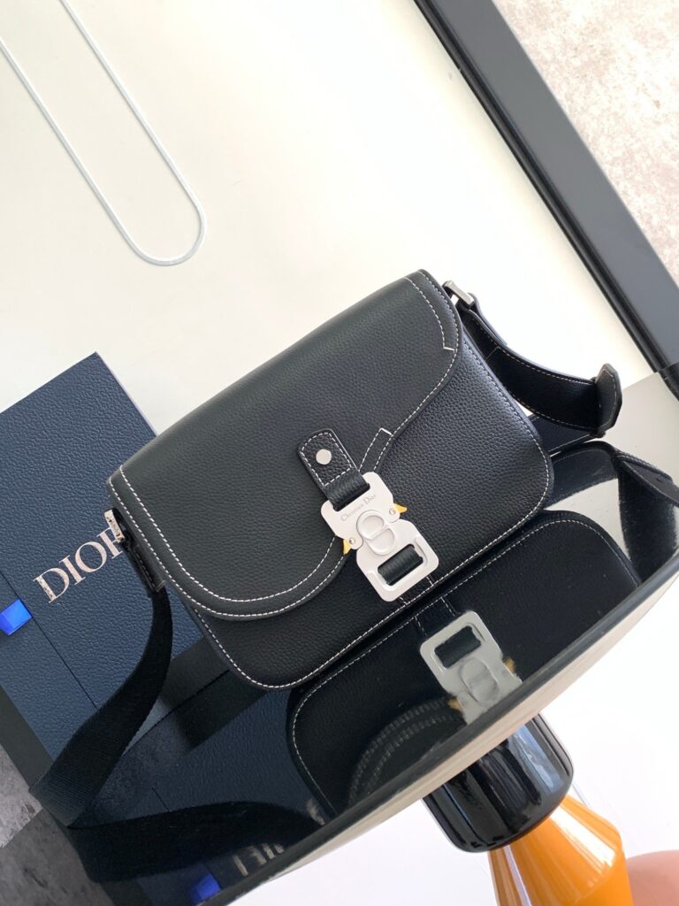 Borsa Dior in pelle nera, elegante e moderna, con riflesso su tavolo raffinato.