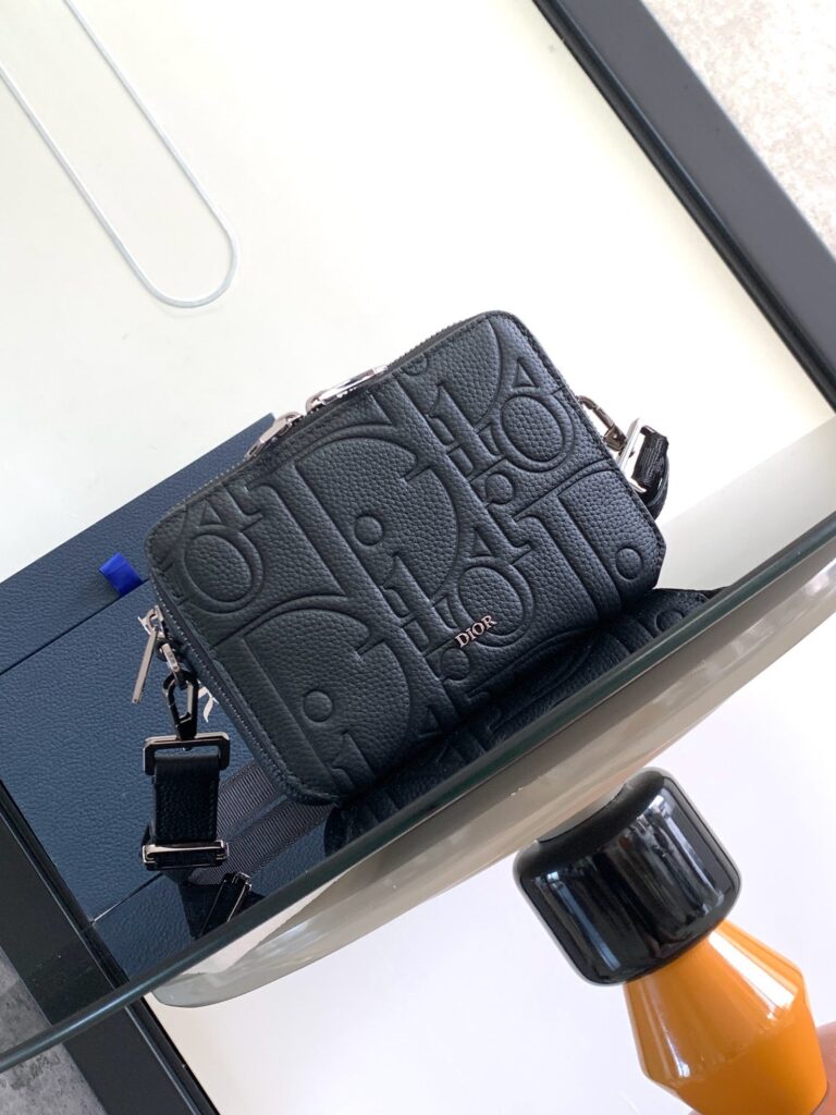 Borsa nera in pelle con logo, dettagli metallici e tracolla removibile, stile elegante e moderno.
