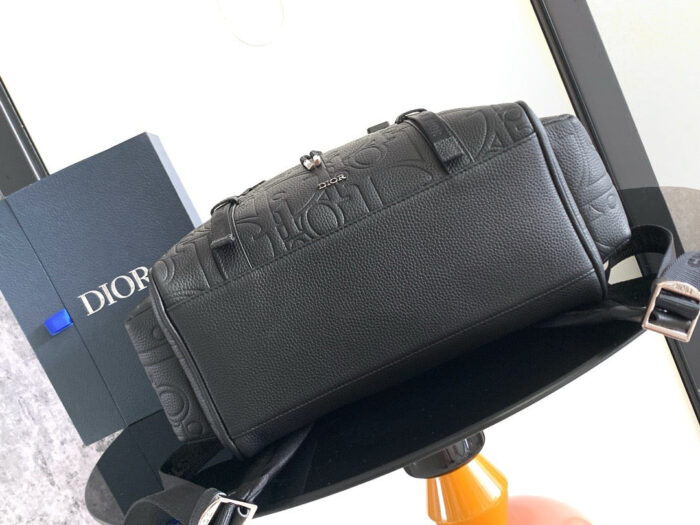 Borsa Dior nera in pelle di lusso su tavolo colorato, stile elegante e sofisticato.