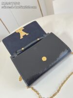 Borsa nera in pelle con dettagli dorati, fodera blu e tracolla chain elegante.