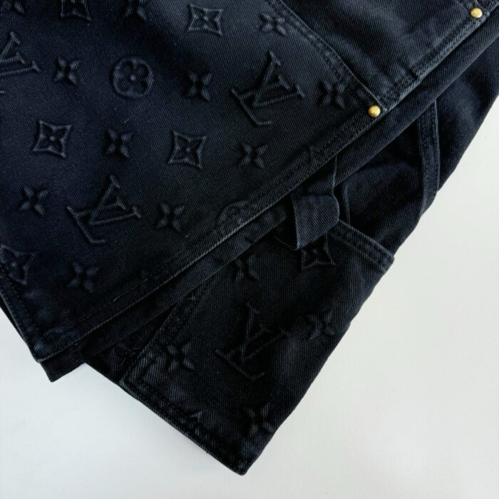 Jeans Louis Vuitton nero con monogramma embossato, dettagli metallici dorati e finiture di lusso.