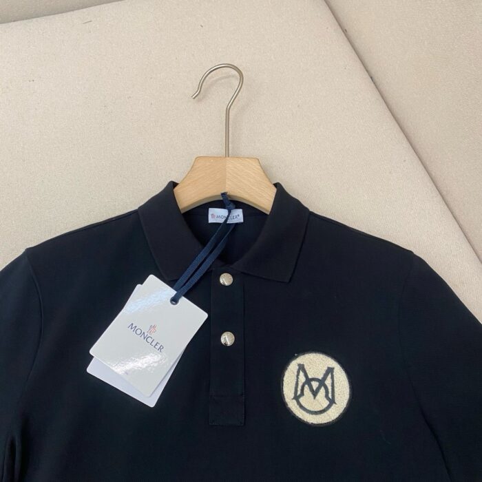 Maglietta polo nera Moncler con logo ricamato, stile elegante e alta qualità.