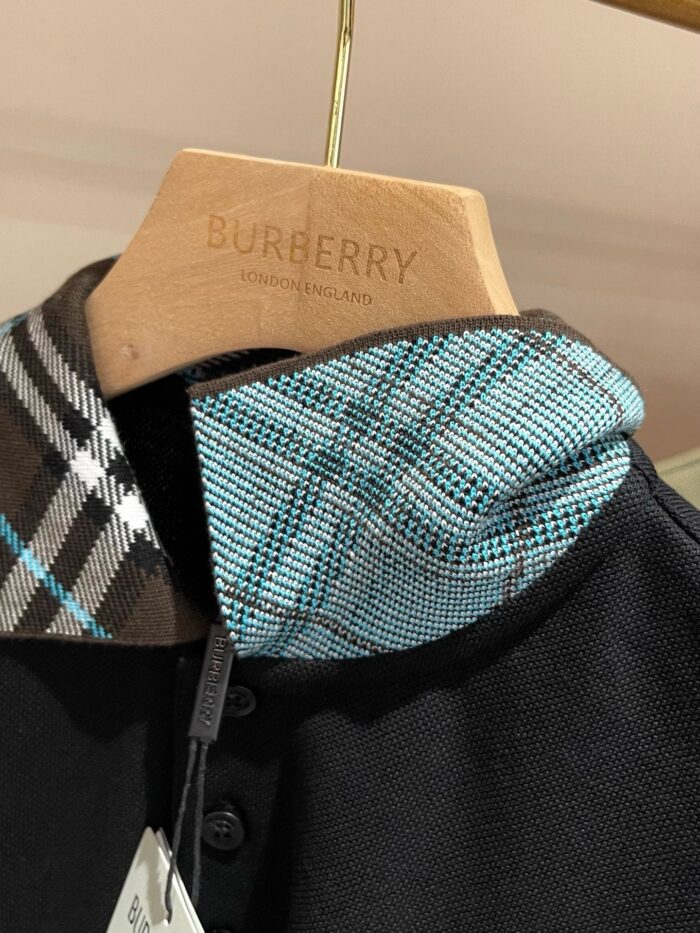 Maglietta polo nera Burberry con colletto check colorato, dettagli di lusso e stile raffinato.